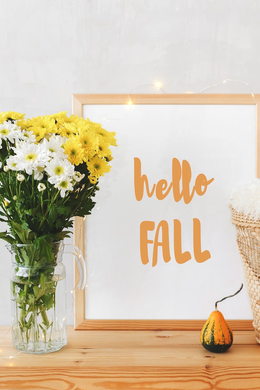 add color to fall decor -pictured vase with yellow and white mums and hello fall sign