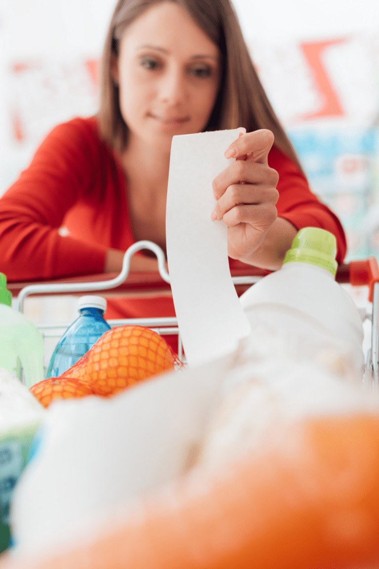 woman looking at grocery receipt in the store