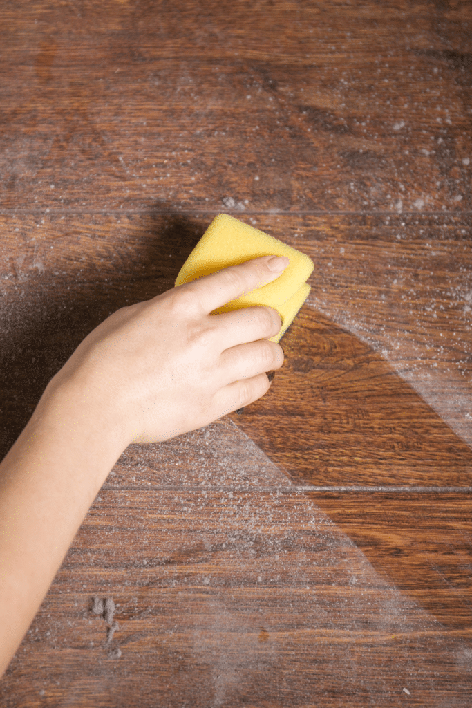 Dusty tabletop with woman cleaning dust off - Dust buildup